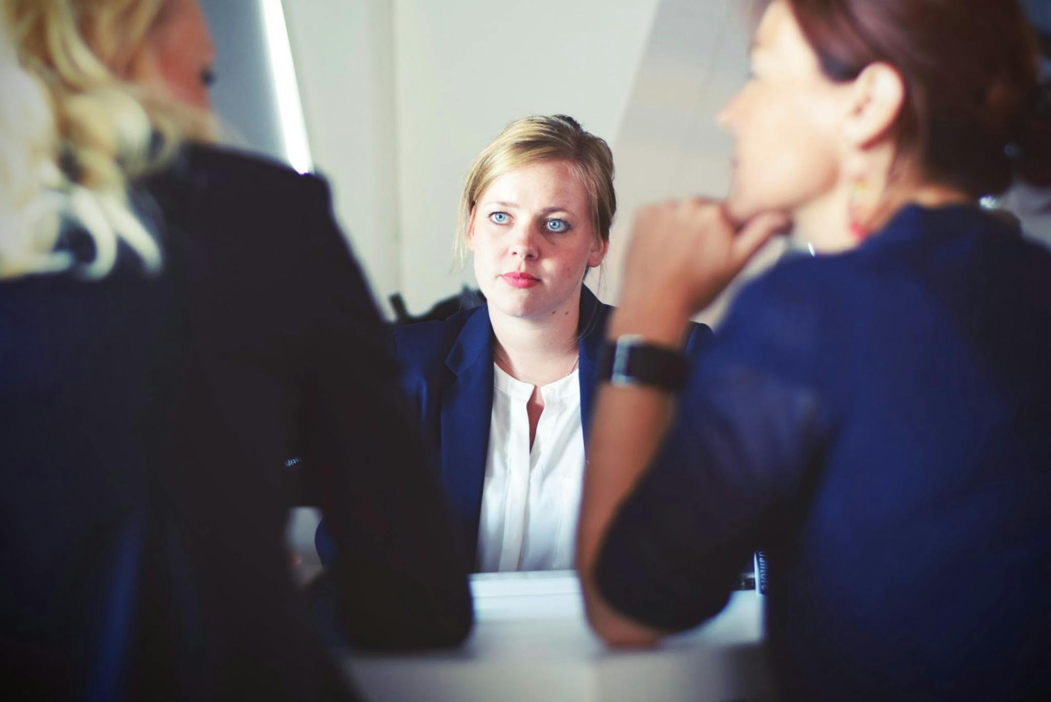 Focused discussion during a business meeting featuring three women.